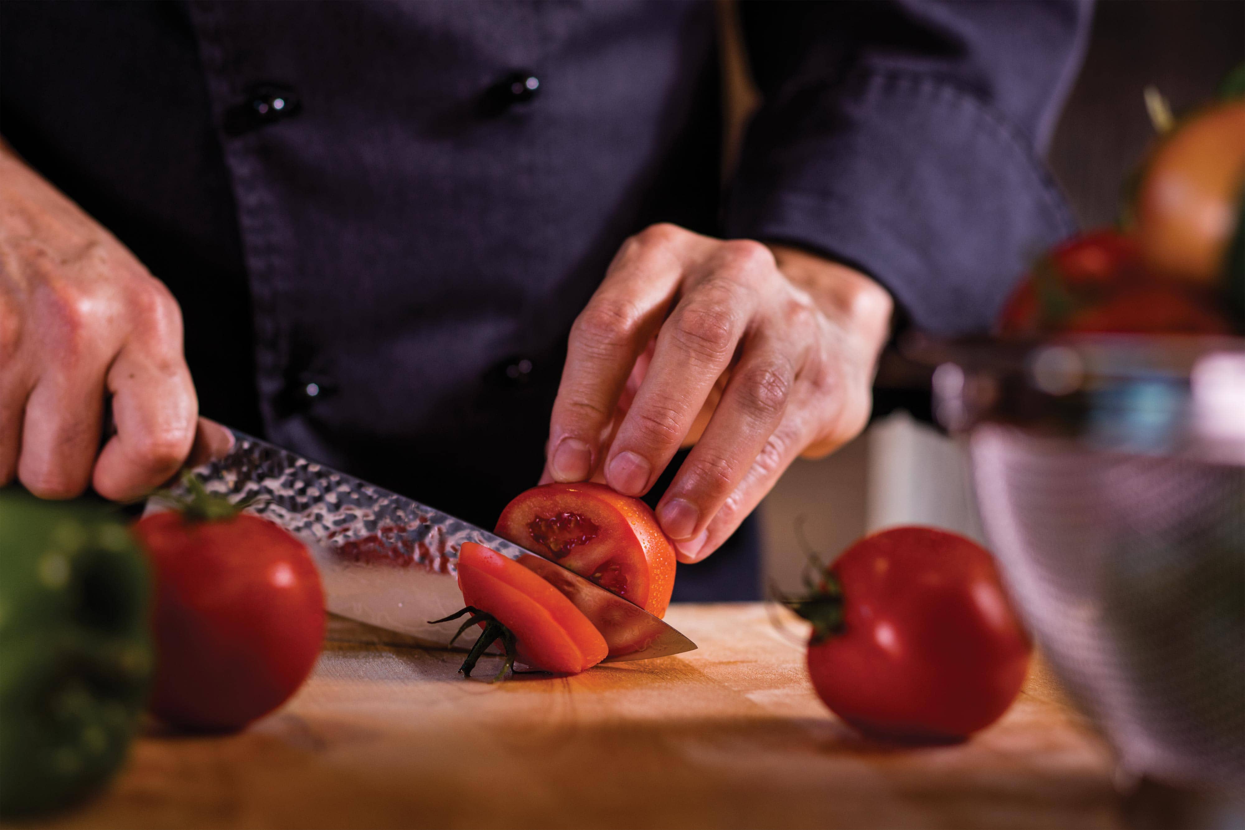 Pizza Cucina Chef slicing tomatoes